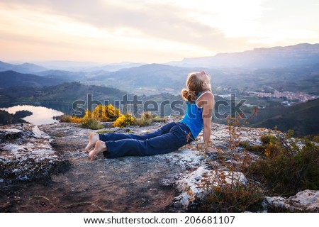 Young Caucasian woman performing upward facing dog pose outdoors