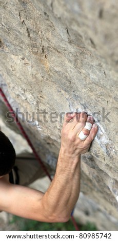 Rock climber\'s hand grasping handhold on cliff