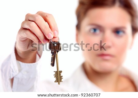 Young caucasian woman holding keys. Image with shallow depth of field, the keys in focus.