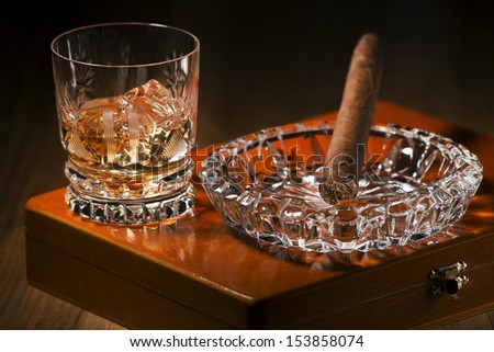 Whiskey and cigar on wooden box close up