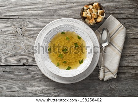 Fresh chicken or beef soup on wooden background overhead shoot