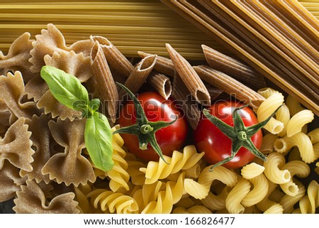 Raw pasta with basil and tomato overhead shoot