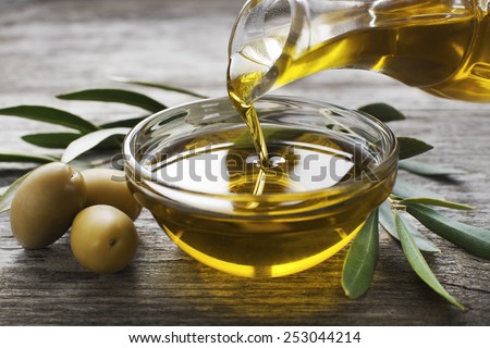 Bottle pouring virgin olive oil in a bowl close up ストックフォト © 