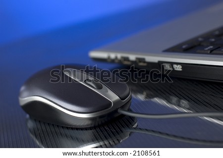 laptop computer with mouse on reflective surface  close up