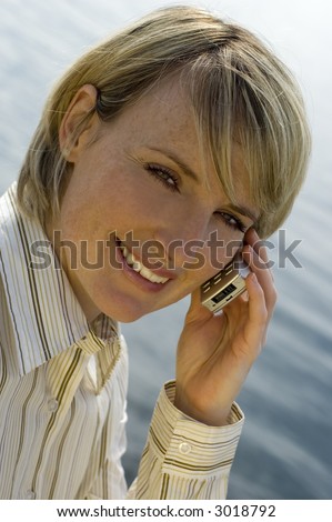 young woman calling by mobile phone by sea side