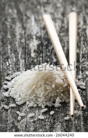 raw white rice with chopsticks close up