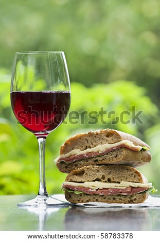Fresh prosciutto sandwich and red wine outdoor close up