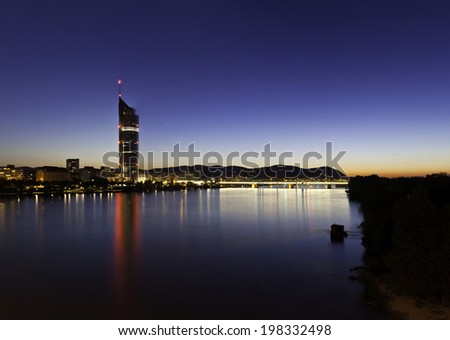 Cityscape of Vienna with the so called Millennium Tower at the Danube River in the summer at dusk with the very last sunshine.