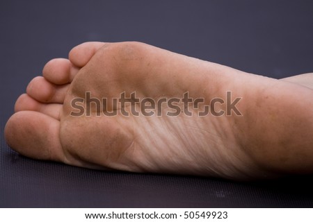 sole of girls dirty foot on black background