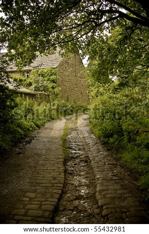 An old cobbled road leading to a small cottage.