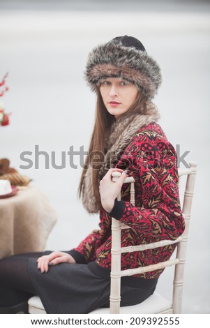 beautiful girl in the park in winter, in a fur cap on a romantic dinner