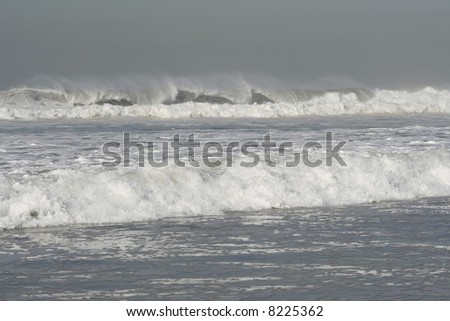 stormy ocean with large waves crashing on the beach