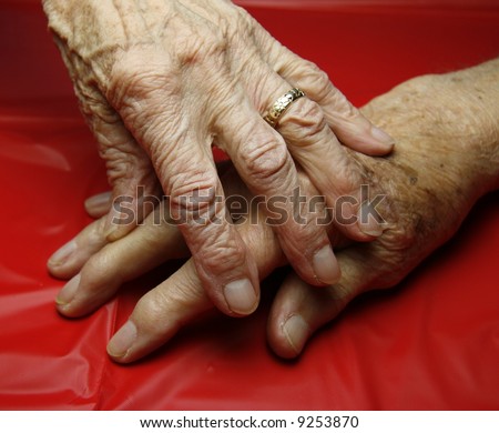 two old wrinkled hands touching one another