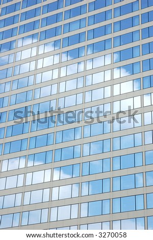 Building windows reflection of blue sky and clouds