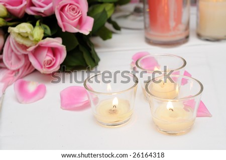 Beautiful pink roses with candles over white