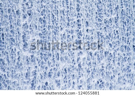 Water curtain - rushing water in front of a stone retaining wall