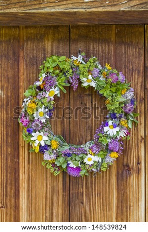 Fresh flower wreath at the door of an old hut