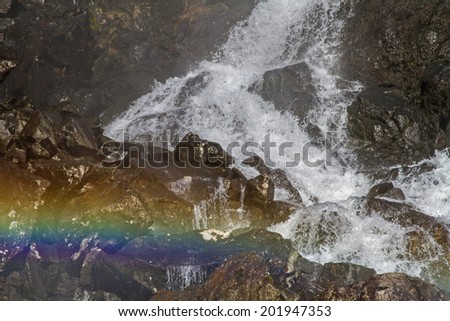 Sun rays which  meet on the fine dust of the waterfall that shine in the glorious colors of the rainbow