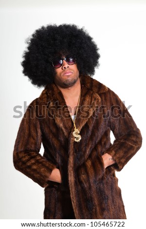 Hip hop urban black man retro afro hair wearing fur coat and golden jewelry isolated on white. Looking confident. Cool guy. Studio shot.