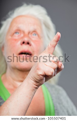 Senior woman white grey hair doing spiritual poses. Expressive face and hands. Studio shot isolated on grey background.