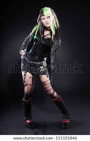 Cyber punk girl with green blond hair and red eyes isolated on black background. Expressive face. Studio shot.