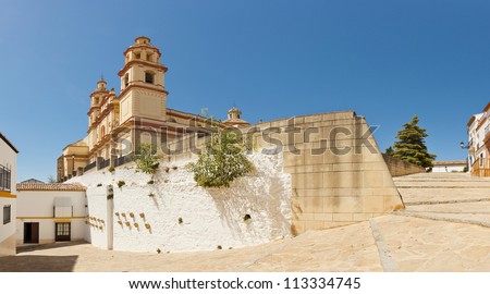 Panoramic photo of the pueblos blancos Olvera. Overviewing plaza with neoclassical cathedral. Iglesia de Nuestra Senora. Old white village. Blue sky. Cadiz. Andalusia. Spain.
