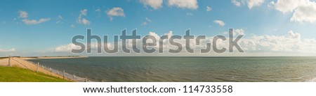 Beautiful panoramic shot of dutch Wadden sea with blue stormy cloudy sky. Texel. Wadden island. The Netherlands.