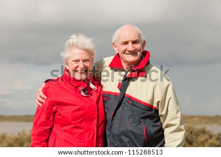 Senior retired couple man and woman enjoying outdoors. Dune landscape with blue cloudy sky. Texel. Wadden island. The Netherlands.