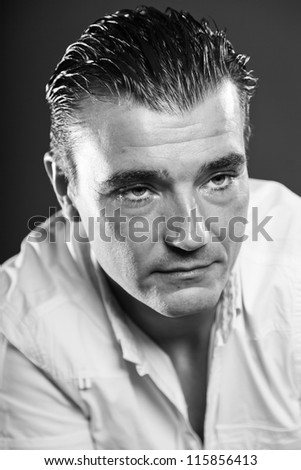Macho handsome man with short brown hair wearing white shirt. Mafia type. Good looking. Fashion studio portrait. Isolated on grey background. Glamour black and white portrait.