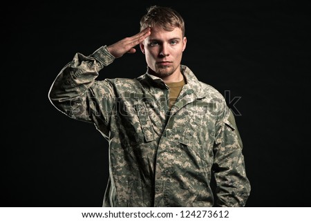 Military young man salutes. Studio portrait.