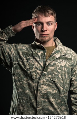 Military young man salutes. Studio portrait.