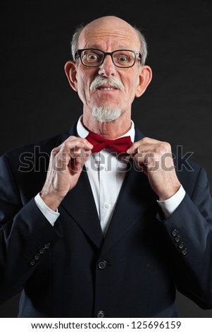 Funny senior man wearing suit and red tie.