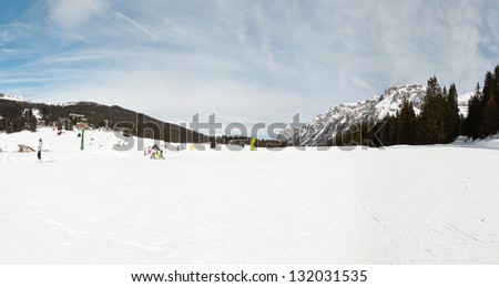 Panorama of winter sport snow mountain landscape with ski tourists.