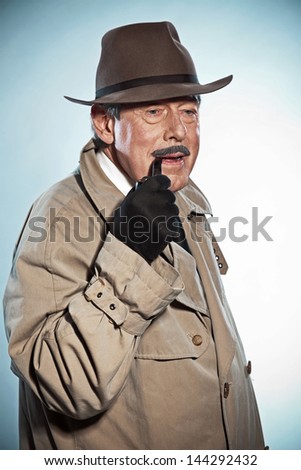 Vintage detective with mustache and hat. Smoking pipe. Studio shot.