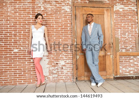 Vintage fashion romantic wedding couple in old urban building. Mixed race.
