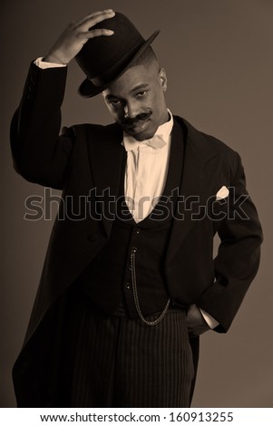 Retro afro american 1900 style man with mustache. Wearing black hat. Taking off his hat.