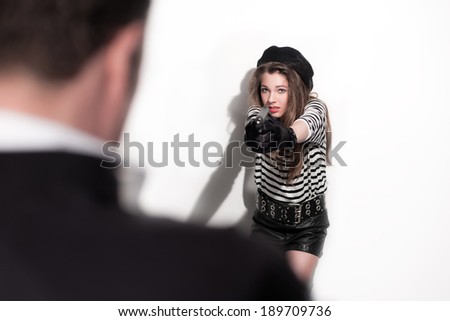 Bold eighties fashion girl in black and white. Shooting on man. Studio shot against white wall.