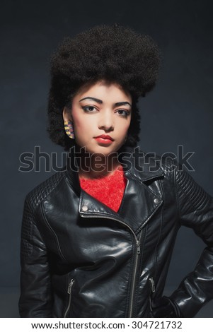 Portrait of a Stylish Young African American Woman in Leather Jacket, Looking at the Camera Against Black Background.