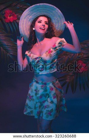Tropical Pin-up Girl with Straw Hat. Evening Light in Front of Palm Leaves.