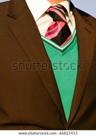 Closeup of groom jacket with green sweater and pink tie
