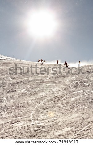 Tourists skiing in winter snow mountain landscape with blue sky. Sunshine. France Alps.