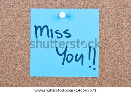 Post it note blue with miss you message on cork