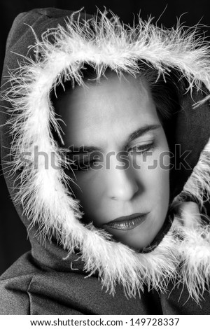Portrait of sad woman in black cape with feather black and white