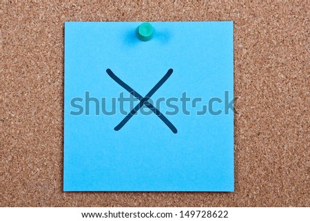 Post it note on wood in blue with wrong cross