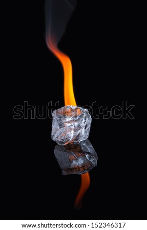 Ice cube melting with flame on shiny black surface