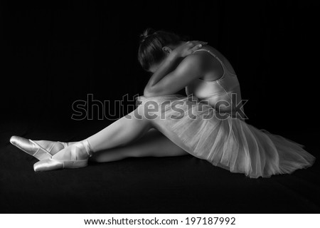 Female dancer sit on floor looking sad in artistic conversion black and white