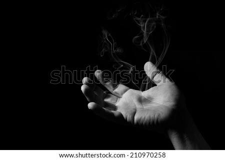 Human hand with hot spot that smokes in artistic conversion