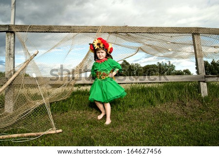 little beauty in the national Ukrainian costume on the background of a fishing net
