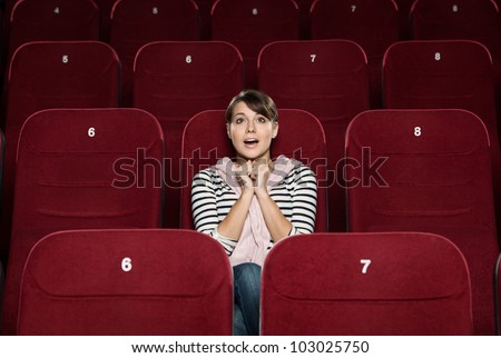 Funky woman watching a movie alone at the cinema