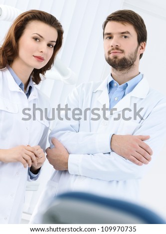 Dentist and his assistant welcome the patient to the dental clinic, white background